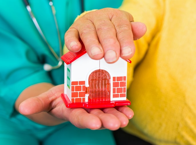 Hands holding a small toy house